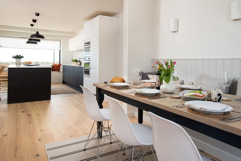 Tide's Watch - the open plan ground floor has a stylish Scandi interior, with large dining table with kitchen beyond