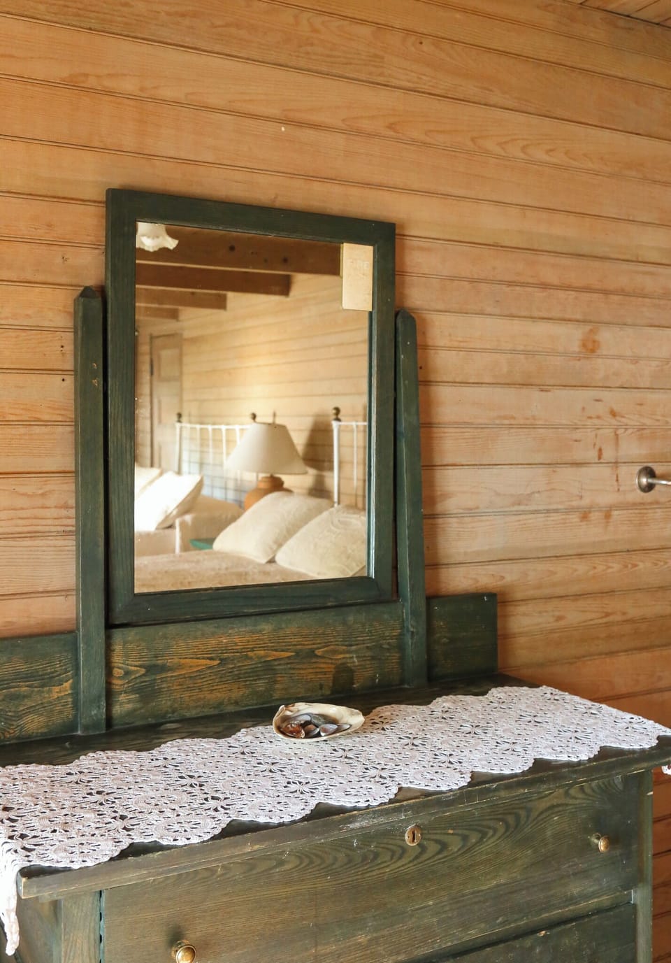 Step into your charming bedroom where rustic wood meets cozy comfort, complete with vintage furnishings and soft linens awaiting your arrival.