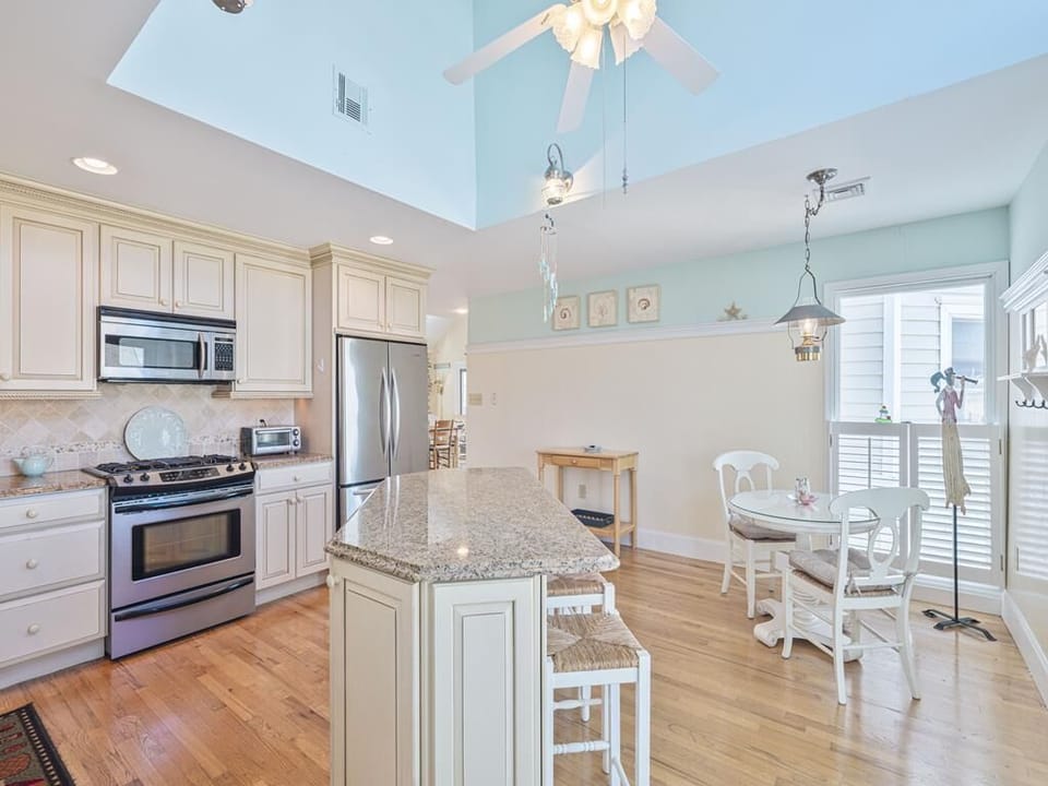 This bright and airy kitchen features modern appliances and a spacious granite island, perfectly designed for family gatherings and coastal cooking.