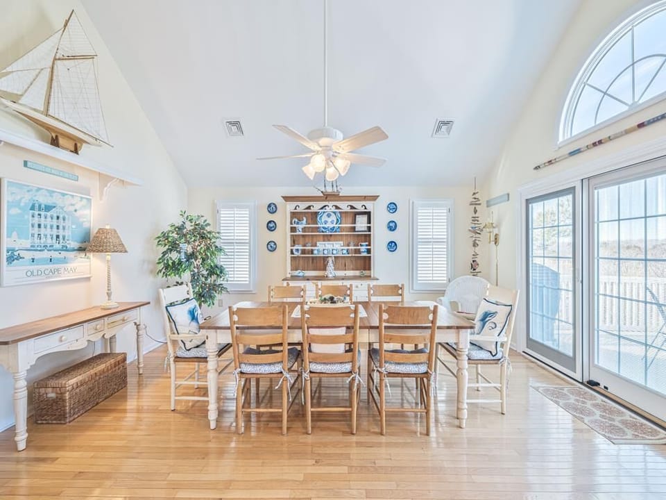 Dine with a view in this charming dining space, perfect for family meals while surrounded by coastal decor and natural light from expansive windows.