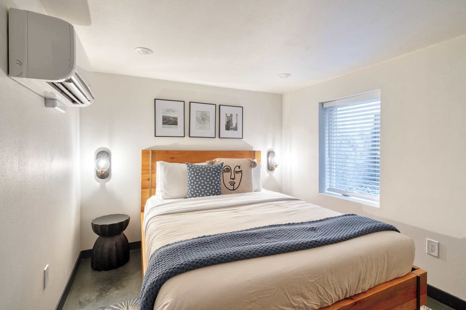 Bedroom with a wooden bed frame and framed artwork.