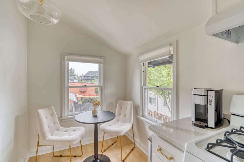 Dining nook with bistro table between windows.