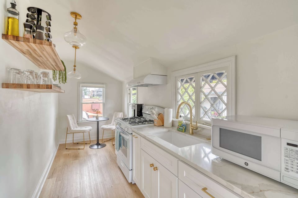 Galley kitchen with gas range and farmhouse sink.