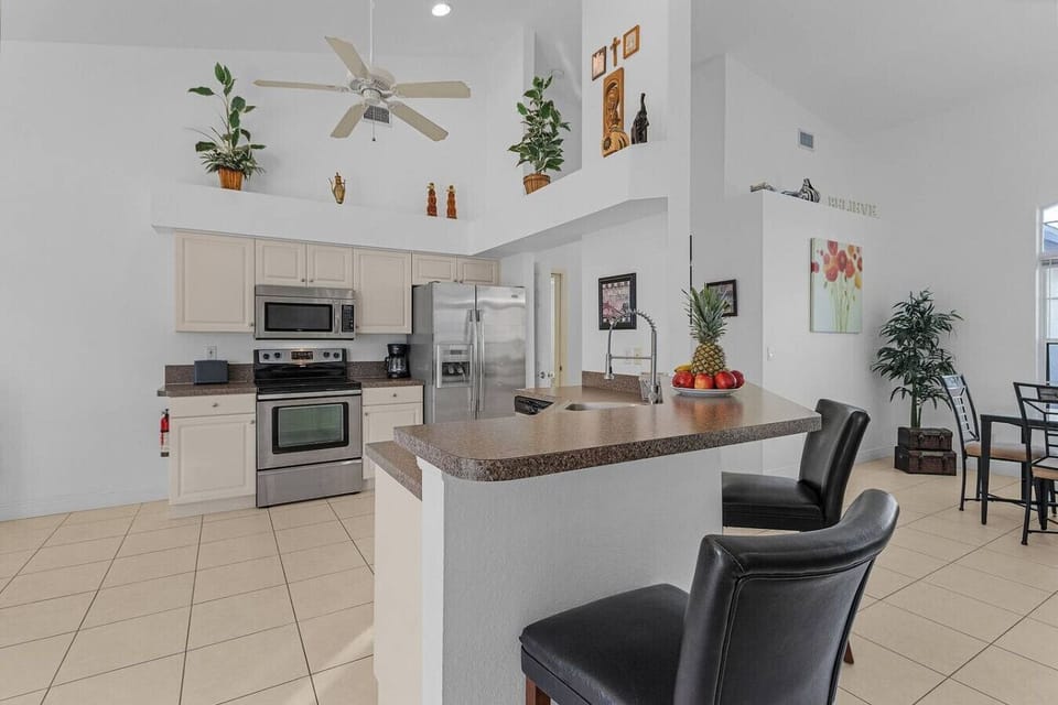 Modern kitchen with breakfast bar and stainless steel appliances, ideal for cooking and entertaining.