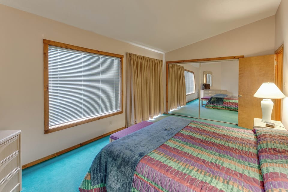 Spacious second bedroom with a queen bed and large windows for a bright and airy feel.
