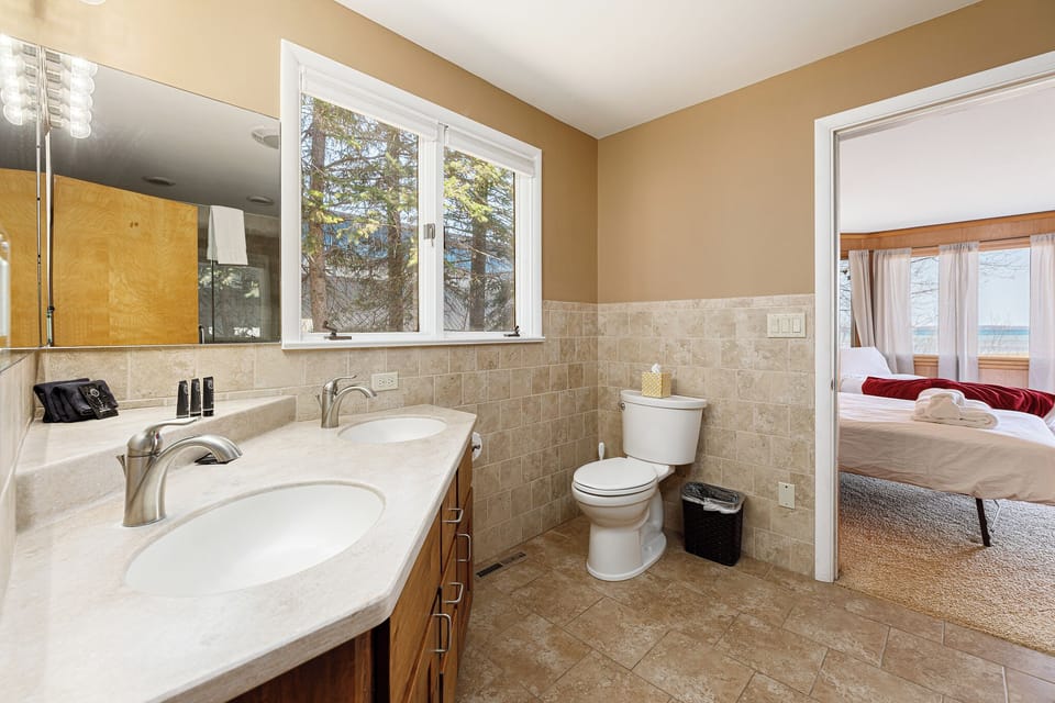 Bathroom w/ double vanity & large mirror, offering plenty of space to get ready.