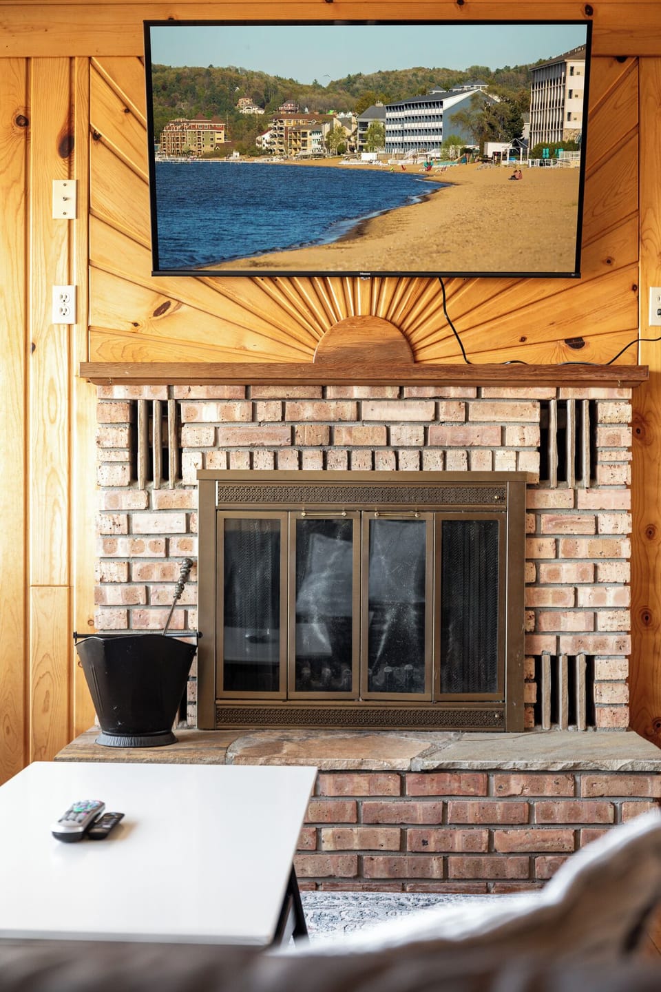 Classic brick fireplace w/ wood mantel, perfect for warming up after a day by the lake.