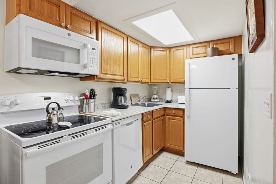 The fully equipped kitchen includes wood cabinetry, modern appliances, and counter space for preparing meals during your stay.