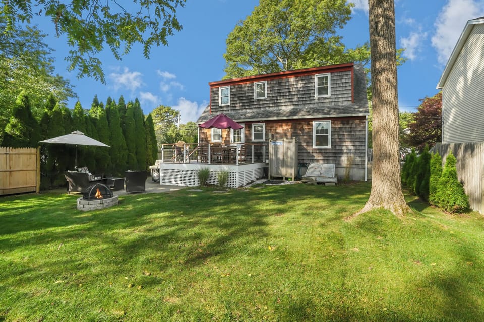Backyard which includes gas grill, fire pit, patio seating and deck