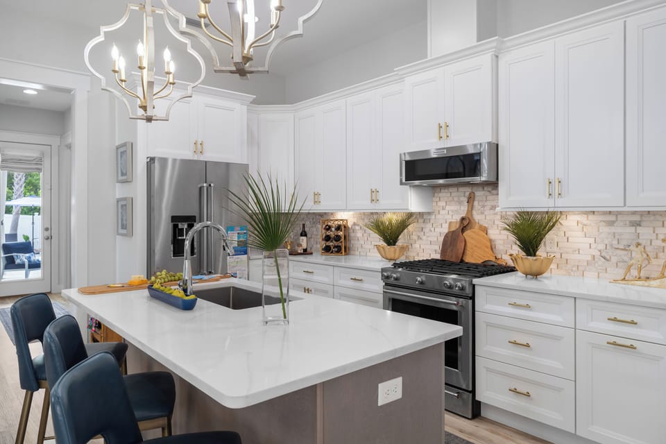 Sleek kitchen with a breakfast bar, stainless appliances & pendant lighting.