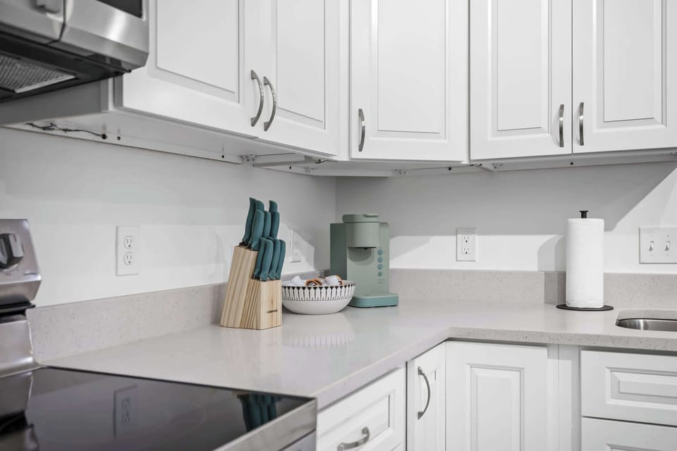 Modern kitchen corner with white cabinetry and essential appliances