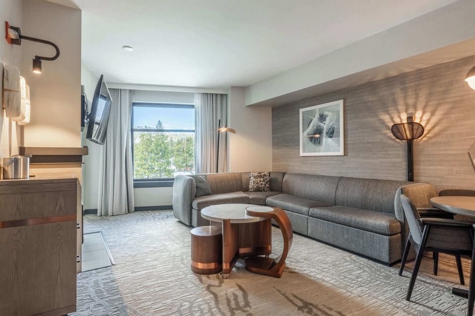 Living area with balcony, sectional sofa, gas fireplace, and Smart TV