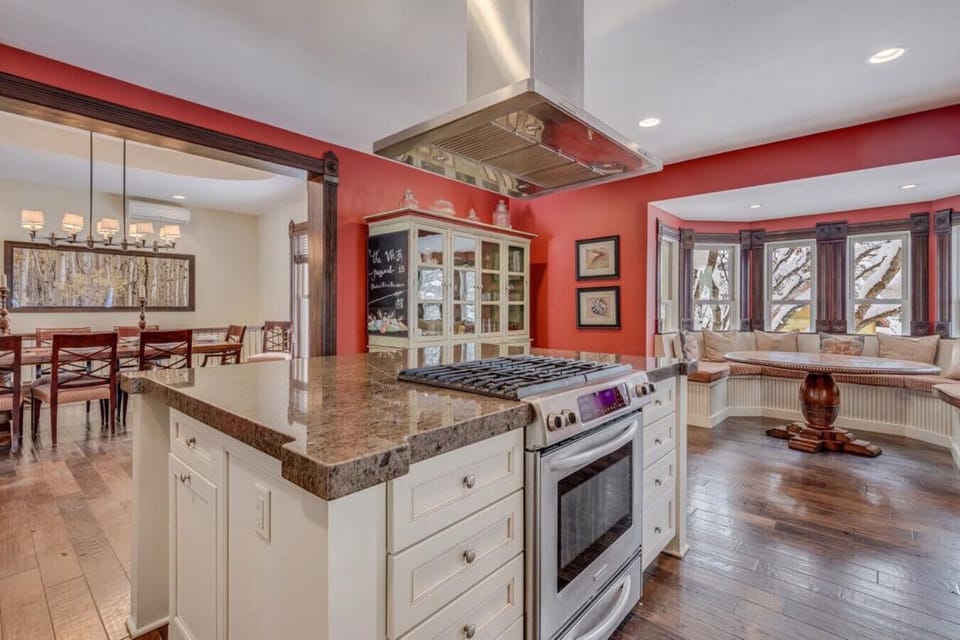 Main Kitchen: Kitchen features a gas stove and large island and is flanked by a dining room and a breakfast nook