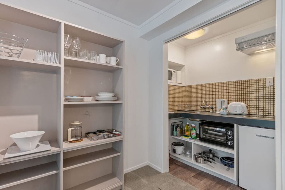 The kitchenette is well stocked with plates, cups, mugs, coffee plunger, toaster, and kettle.