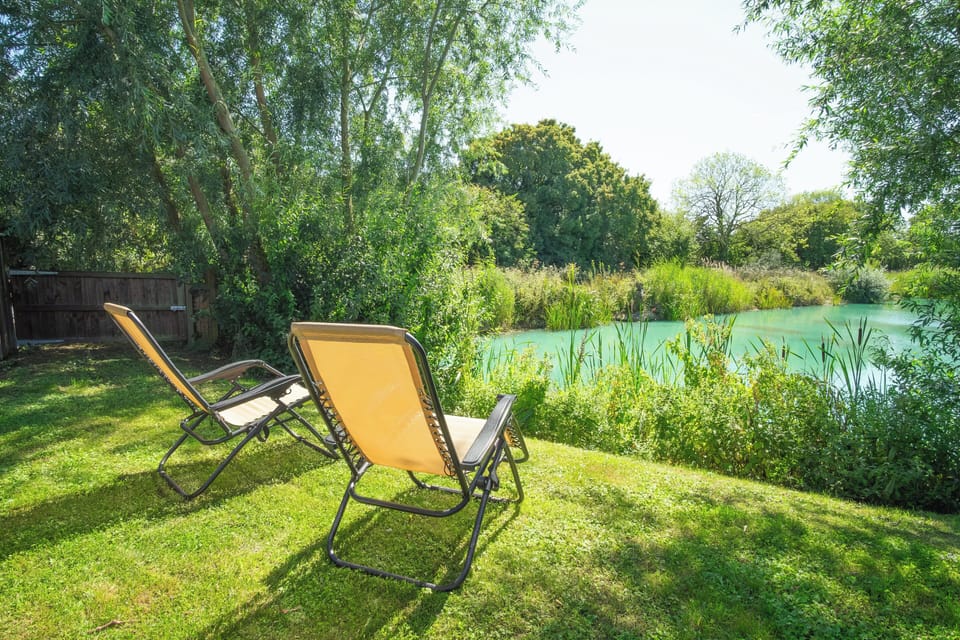 The garden area of Ash lodge overlooking one of our fishing lakes, with loungers (four in total). 