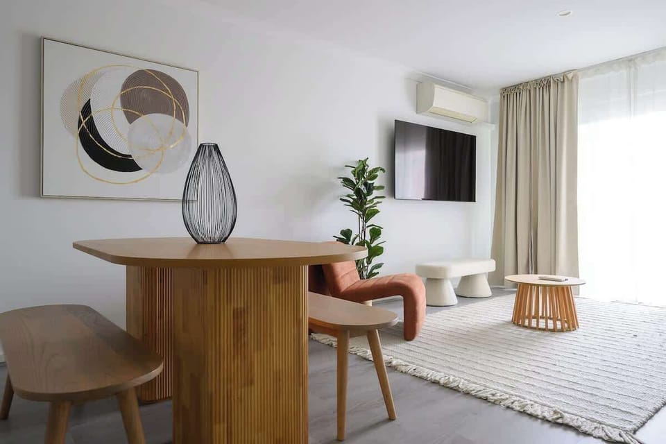 Enjoy a seamless flow from the curated dining area to the sun-drenched lounge. Featuring a modern wooden dining set, large smart TV, and designer furniture, this space is built for style and comfort.