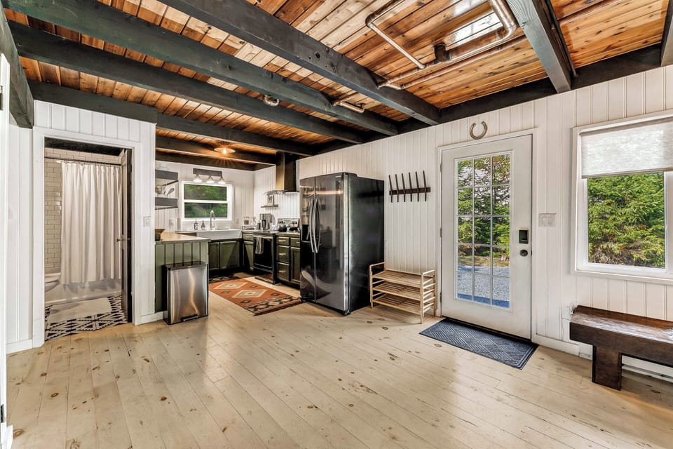 This modern kitchen is fully stocked with everything you need for cooking and entertaining, with direct access to the first-floor bathroom for added convenience.