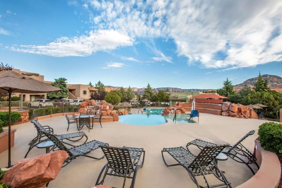 Lounge poolside under big skies and red-rock views.