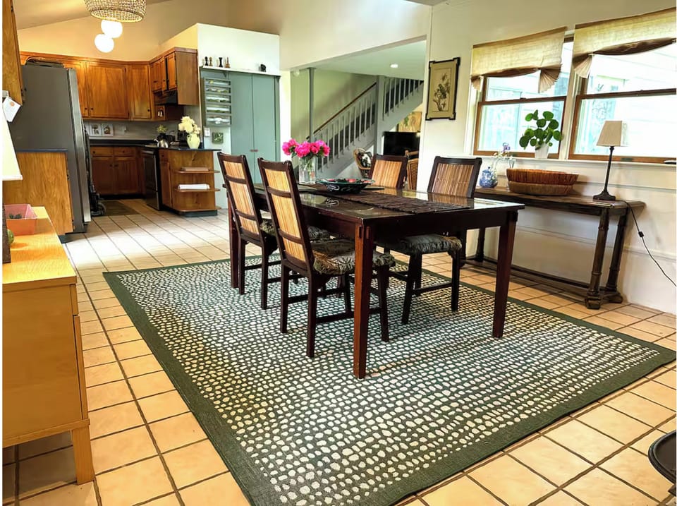 Dining area with kitchen in background of photo.
