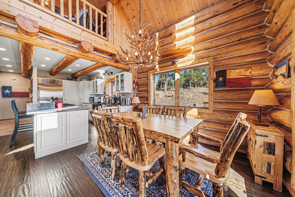 Rustic log cabin charm meets modern convenience in this stunning dining space where your family meals become mountain memories.