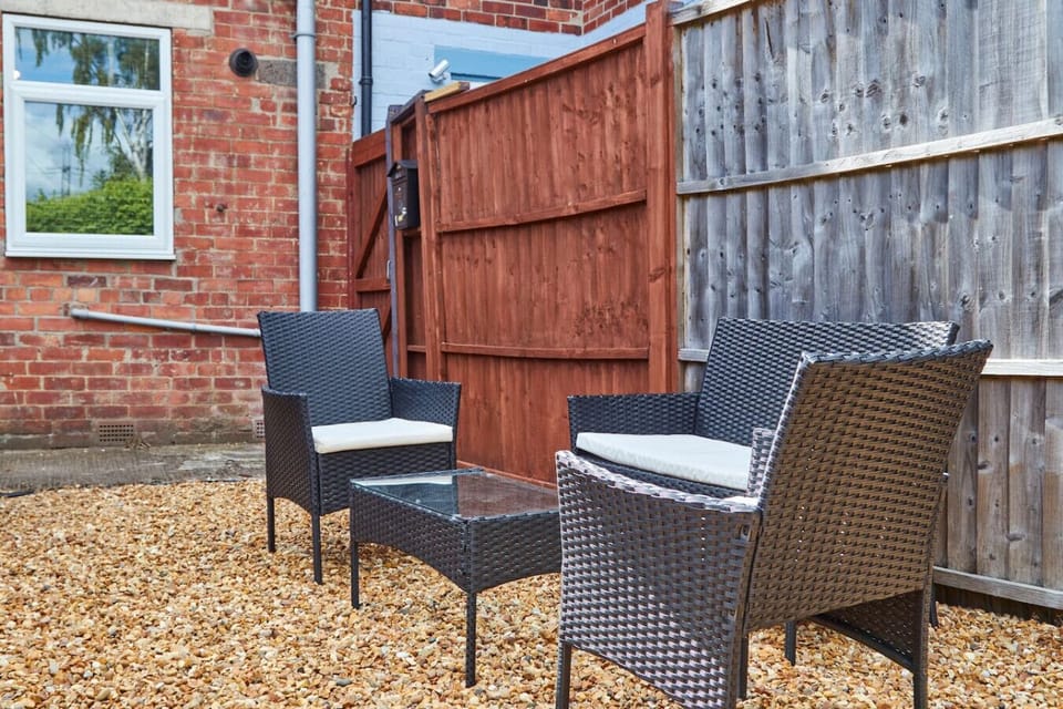 Fully fenced garden with outdoor seating.