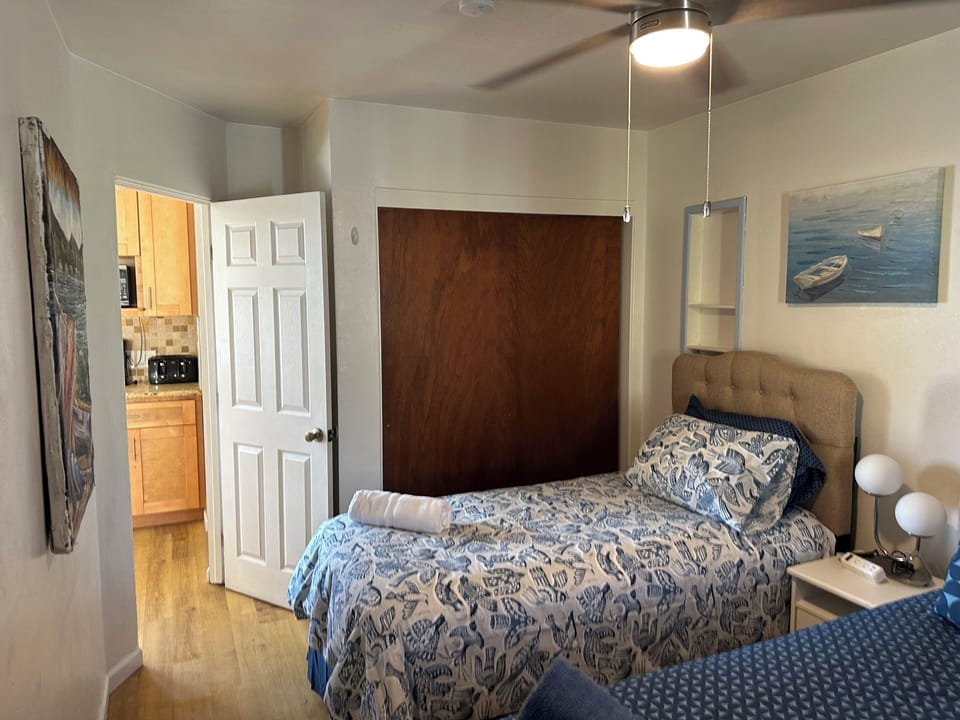 View of entry way from inside bedroom.  Good size closet & ceiling fan.  Also AC