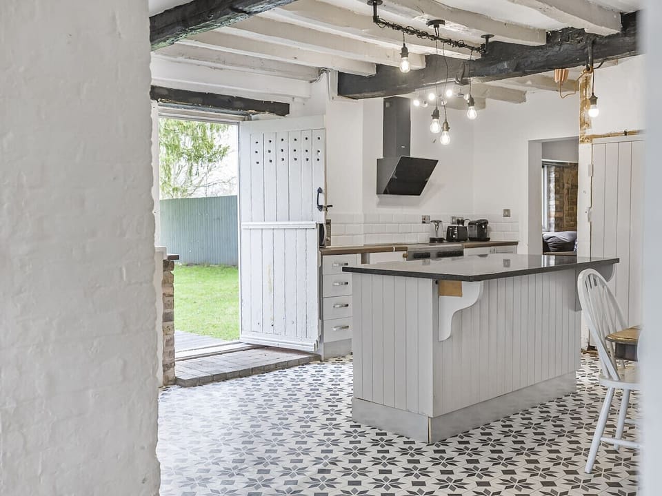 Equipped open plan kitchen with dining table opening up to the garden