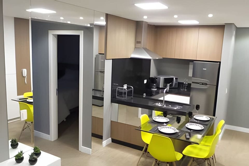 Cozinha equipada com mesa de jantar e eletrodomésticos