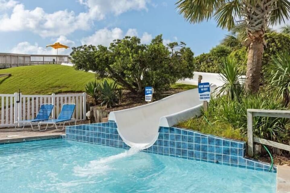 Dive into fun with a thrilling water slide at the pool, perfect for kids and adults alike on a warm sunny day.