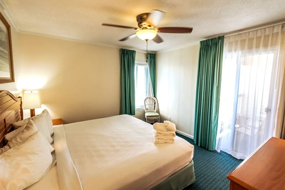 Enjoy a serene bedroom with direct beach access, featuring a full kitchen, private balcony, and family-friendly layout just minutes from Fort Macon and Morehead City.