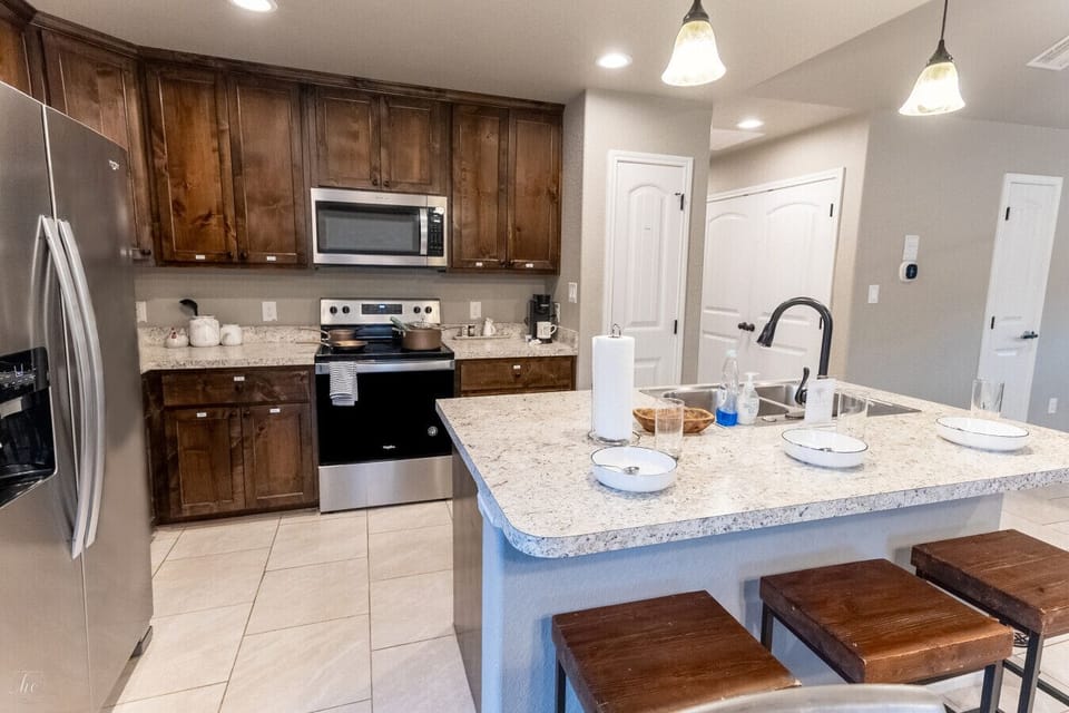Fully equipped kitchen with granite island, stainless appliances, and bar seating — cook for the whole crew