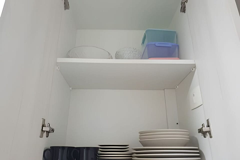 Cozinha - Tigelas de vidro, potes de plástico, pratos, pires e xícaras.