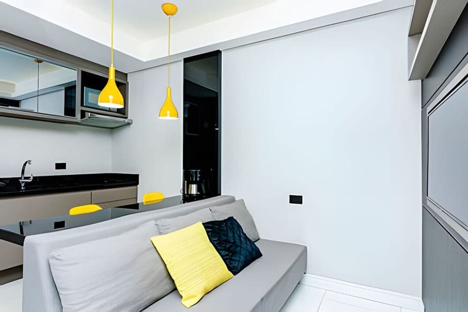 Sala/Cozinha - sofá 3 lugares, micro-ondas, balcão 2 cadeiras, pia e armários.