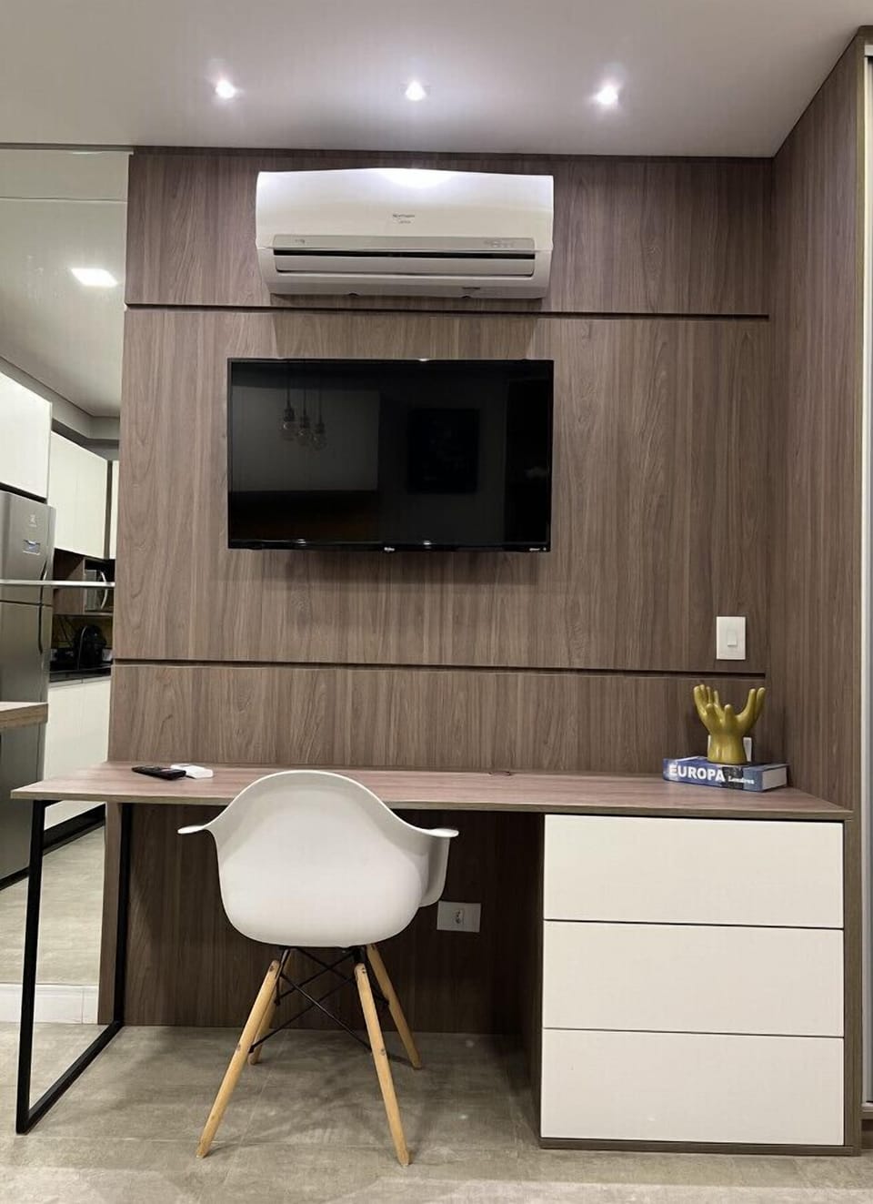 Sala com televisão e mesa de leitura/reuniões.