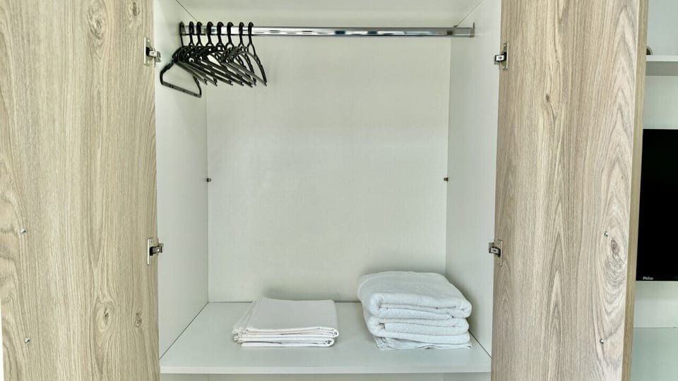 Closet com varoes para roupas e prateleiras organizadas