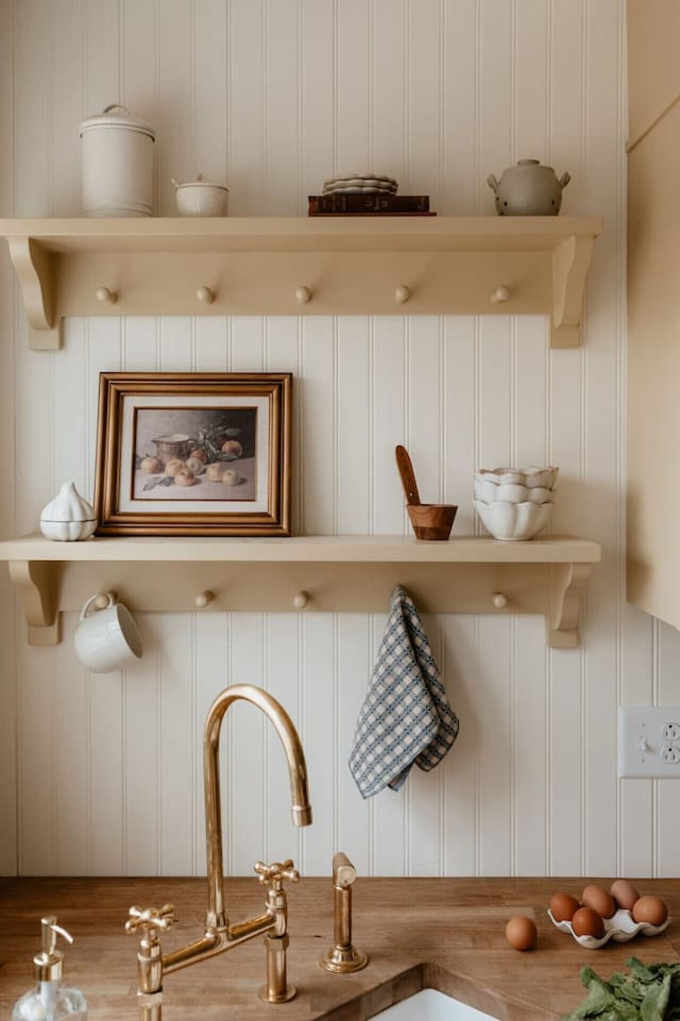 Thoughtfully arranged kitchen shelves with beautiful brass details