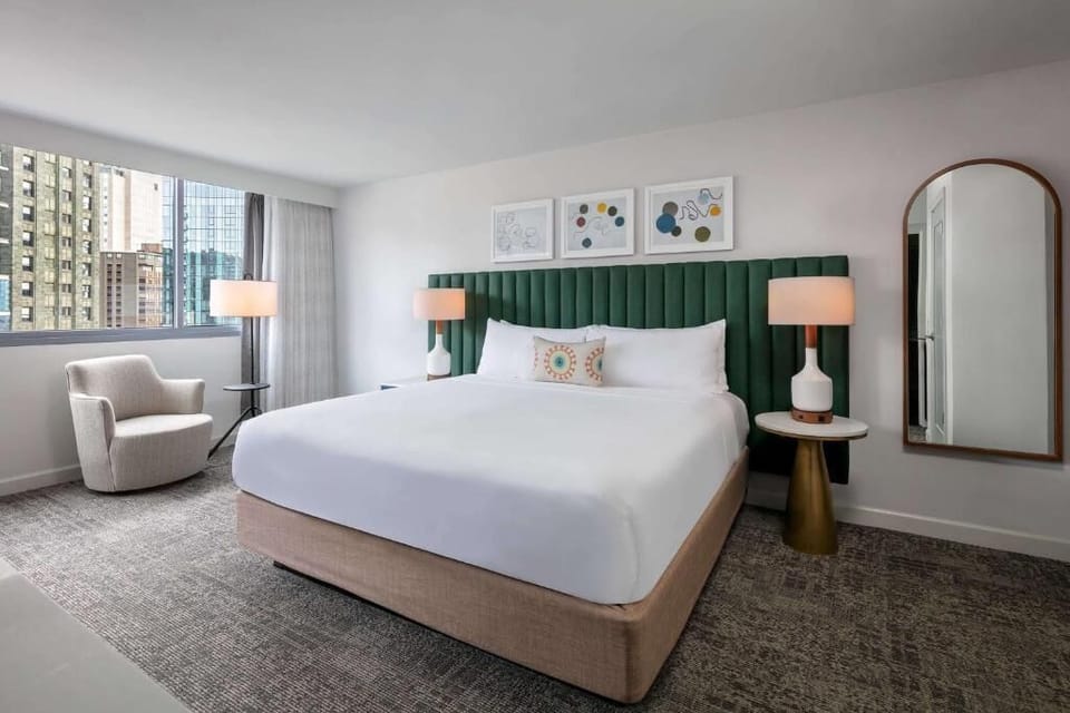 Unwind in a serene bedroom with plush bed and city views.