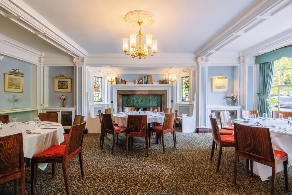 Gather for elegant meals beneath warm chandeliers and bay windows.