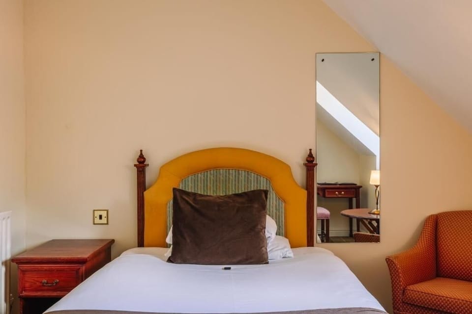 Unwind into crisp linens beneath cozy attic-style ceilings.