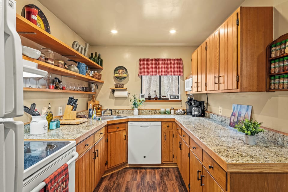 Full kitchen with ample counter space, wood cabinetry, and warm tones.