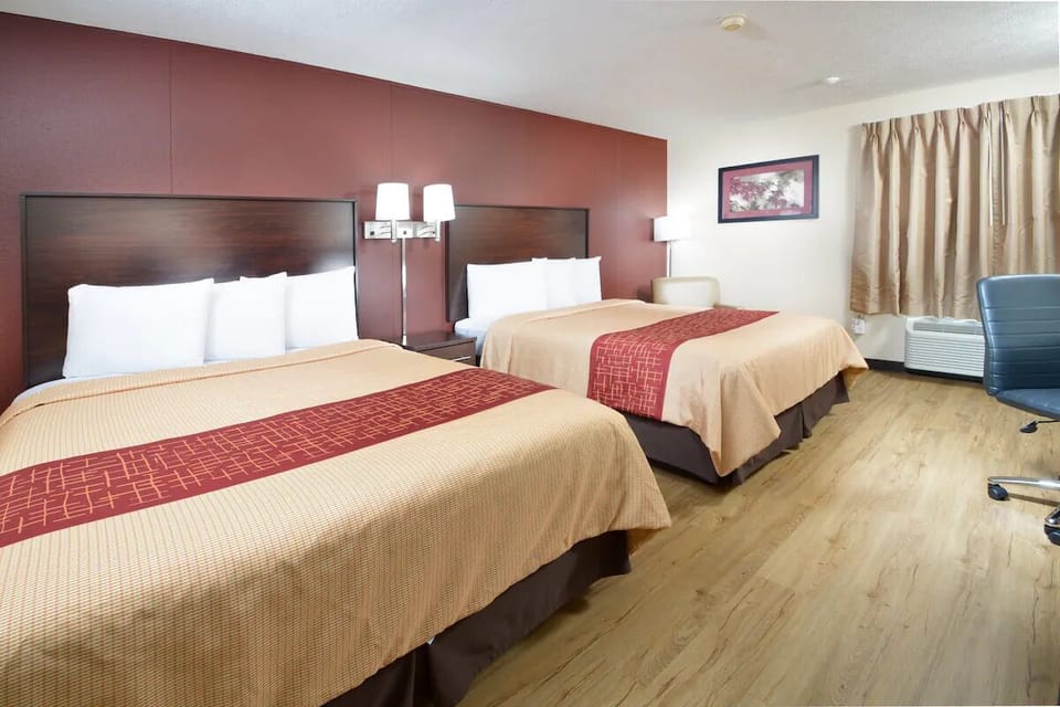 Unwind in a spacious double-queen room with warm lighting.