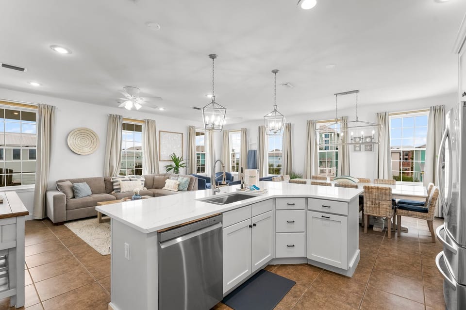 Bright open-plan living with modern kitchen island, cozy seating, and panoramic windows flooding your space with natural light.