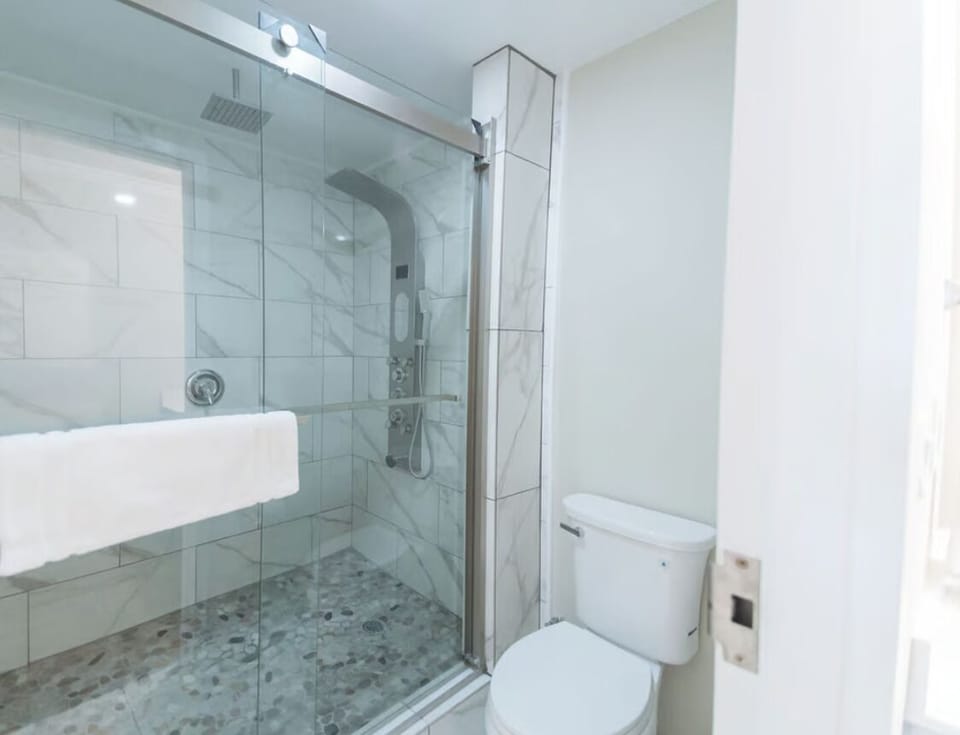 Rinse off comfortably behind crystal-clear glass and marble tile.
