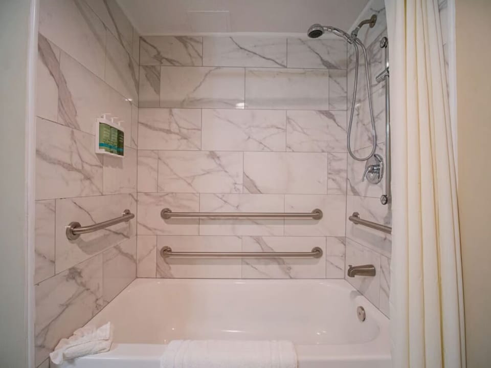 Rinse off under the rain shower in a tiled tub.