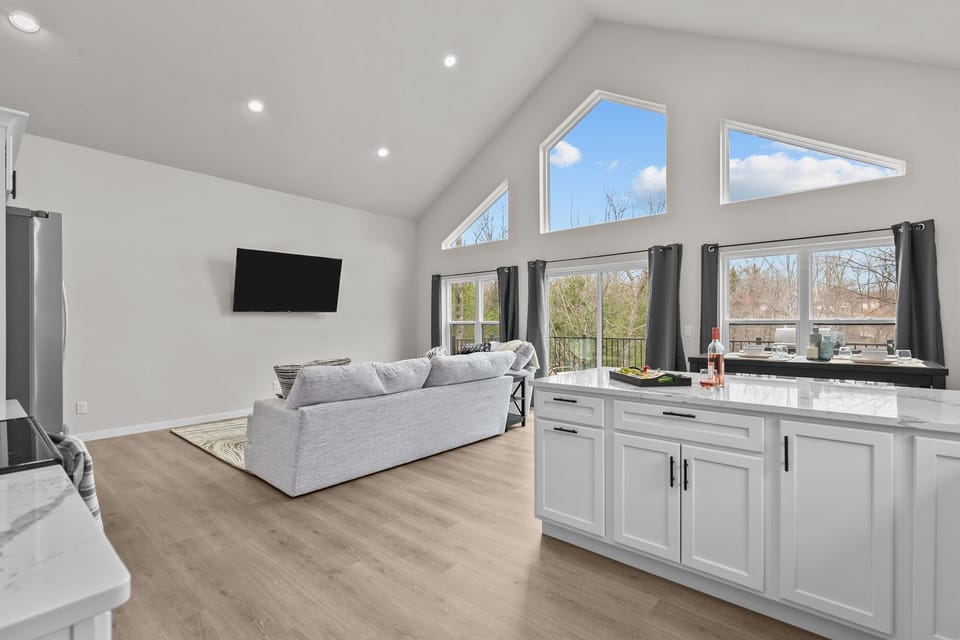 With its open-concept design, this space keeps everyone connected—whether you're cooking in the kitchen, relaxing in the living room, or gathered around the dining table, conversation flows as easily as the lake breeze.