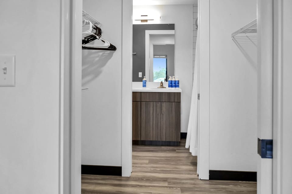 Walk-through closet with shelving for storage and hanging items to stay organized!