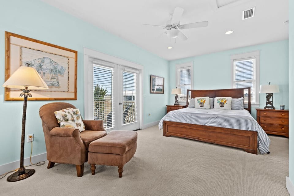 Spacious bedroom with king bed, comfy seating, and private balcony access.