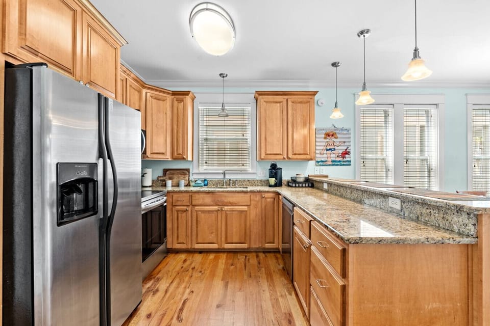 Cook up your favorite meals in a fully stocked kitchen featuring granite countertops, stainless steel appliances, and coastal charm.