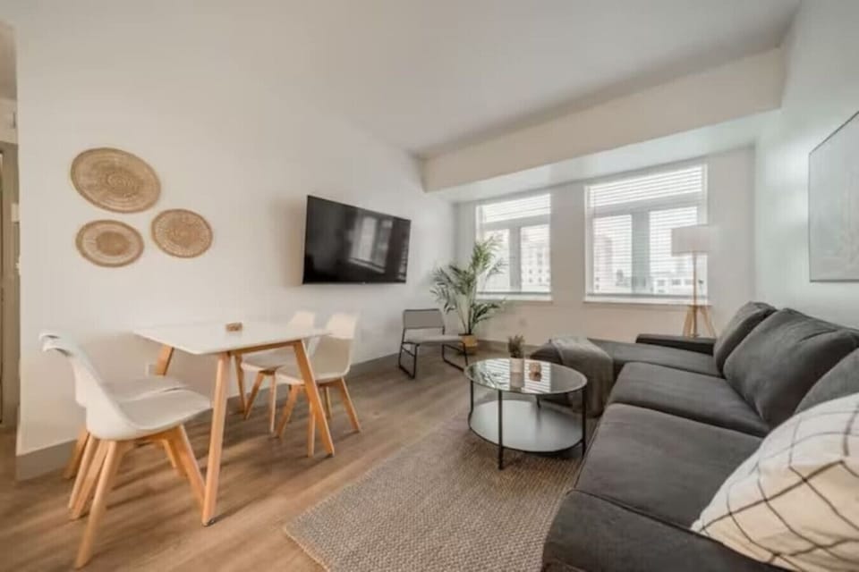 Spacious open-concept living and dining area featuring a vibrant sofa, modern furnishings, and a stylish entertainment setup—ideal for gatherings and relaxation.