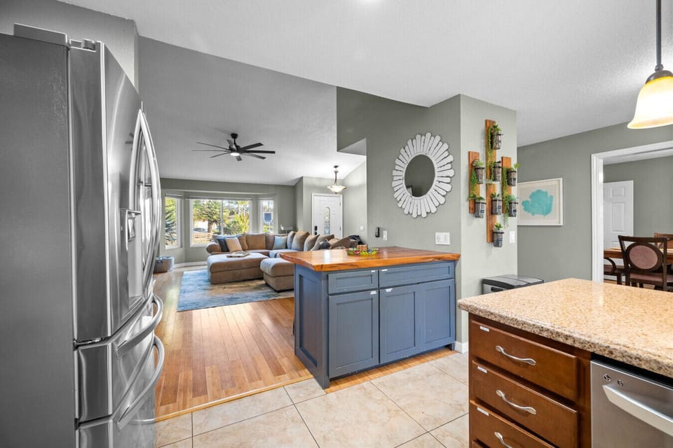 Fully equipped kitchen with granite countertops, stainless steel appliances, and open flow to living space.